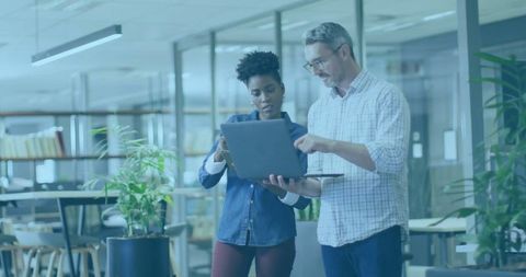 Colleagues Collaborating in Modern Office With Laptop