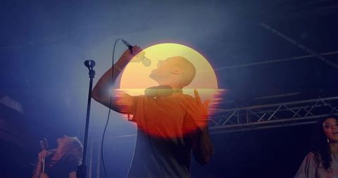 Sunset double exposure singer performing live with headphones on moody concert stage