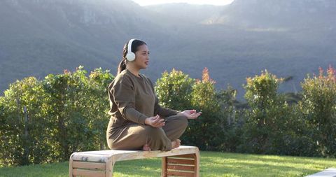 Woman Meditating Outdoors in Nature Wearing Headphones