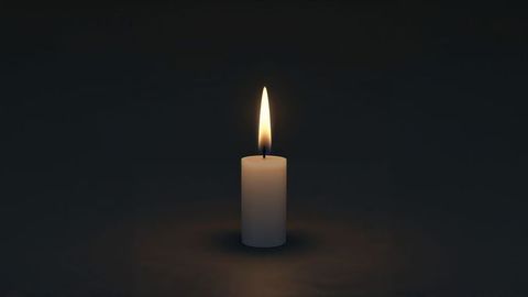 Minimalist white pillar candle burning in darkness for condolences
