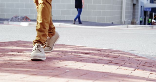 Person wearing beige shoes walking on brick sidewalk in urban setting - Download Free Stock Images Pikwizard.com