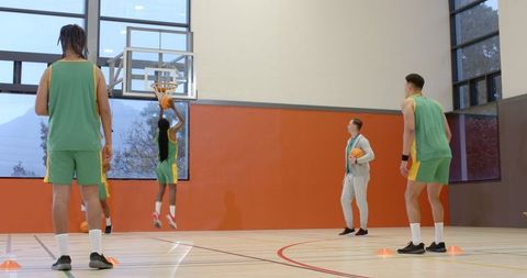 Basketball Players Practicing in Indoor Gymnasium