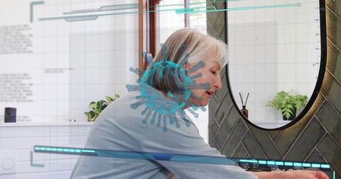 Senior woman washing hands with ar virus overlay in modern bathroom mirror health concept