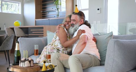Senior Couple Celebrating Birthday with Cake and Champagne at Home
