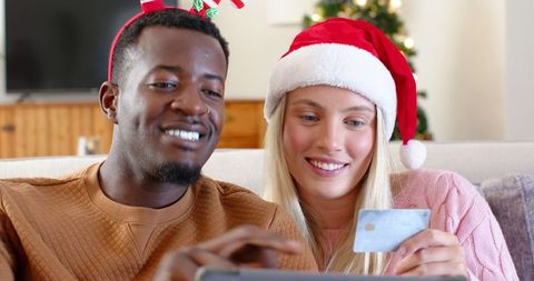 Diverse Couple Shopping Online During Christmas at Home