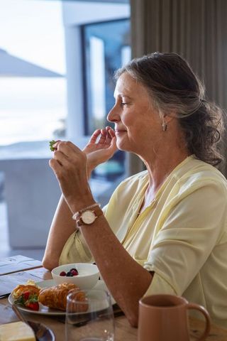 Elegant Senior Woman Enjoying Breakfast in Coastal Home