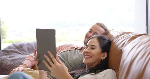 Relaxed Couple Enjoying Tablet Time Together on Sofa
