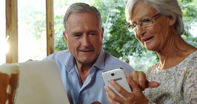 Senior couple engaging with modern technology. Ideal for depicting senior lifestyle, technology for elderly, retirement activities, or family love and bonding themes.
