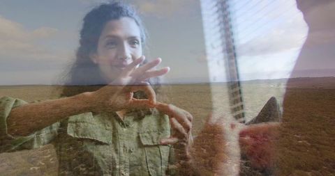 Woman using sign language against scenic landscape background