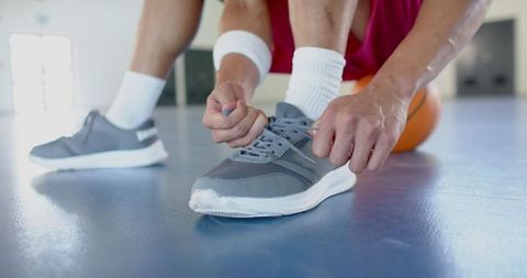 Athlete Tying Shoelaces on Basketball Court in Life Before Game - Download Free Stock Images Pikwizard.com