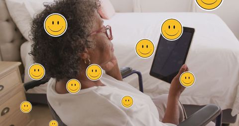 Senior Woman Using Tablet with Digital Emoji Overlay