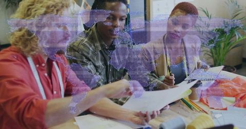 Design Team Collaborating Over Sewing Patterns with World Map Projection