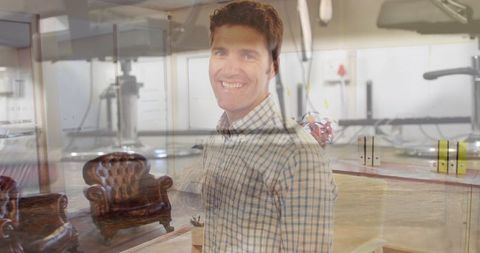 Smiling man in office with modern interior and glass partition