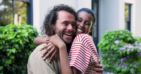 Couple embracing with joy outside their new home