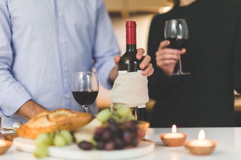 Couple Enjoying Wine and Grapes at Candlelit Table