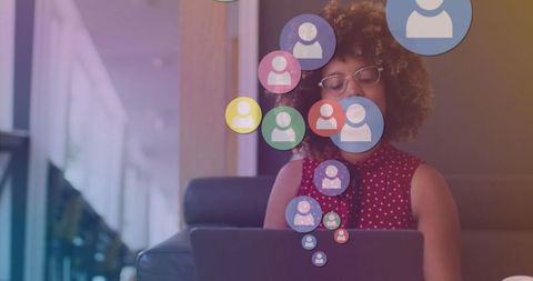 Businesswoman using laptop with floating social media icons