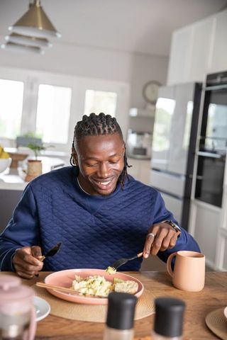 Man Enjoying Breakfast at Modern Home with Bright Interior