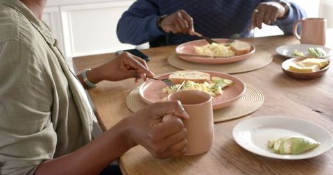 Couple enjoying breakfast with scrambled eggs and avocado toast