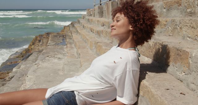 Woman Relaxing on Rocky Seaside Steps on Sunny Day - Download Free Stock Images Pikwizard.com