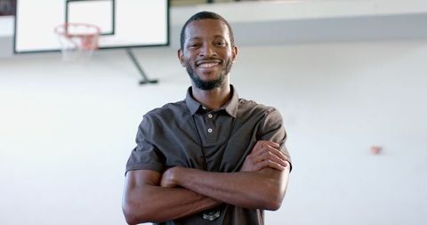 Confident African American Coach in Gym with Basketball Hoop