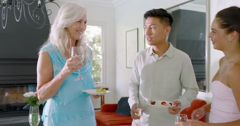 Friends Toasting at Home Gathering with Food and Drink