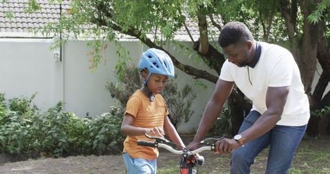 Father Ensuring Son's Safety by Adjusting Bike Helmet