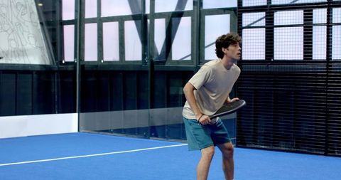 Young Man Playing Padel on Modern Blue Court