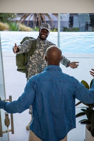 Emotional reunion of military father and son in modern home entrance