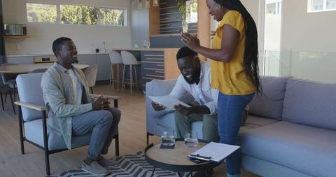 Happy couple consulting with realtor in modern living room