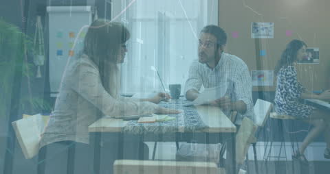 Coworkers Discussing Report with Digital Data Overlay in Office