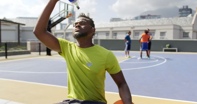 Athlete Cooling Down with Water on Outdoor Basketball Court Under Sunny Sky - Download Free Stock Images Pikwizard.com