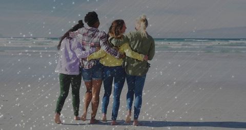 Diverse group of friends embracing at tranquil beach