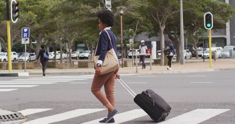 Businesswoman with Luggage Crossing City Street