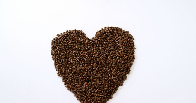Heart-shaped arrangement of coffee beans on white background showing love for coffee. Can be used for coffee advertisements, social media posts celebrating coffee culture, or promotional materials for coffee shops. Ideal as a visual for love-themed coffee events or as decor in a cafe.