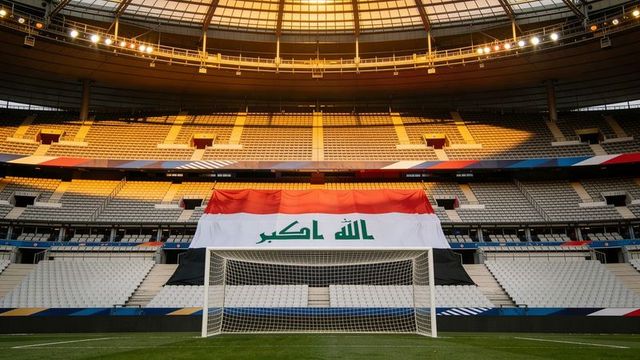 Draping giant iraqi flag behind goal on empty domed stadium pitch at golden hour