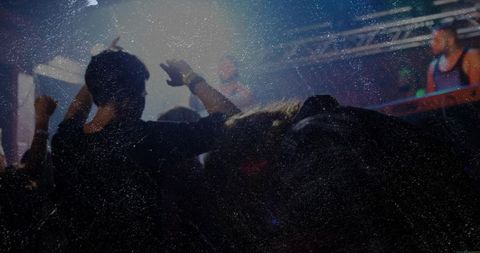 Energetic crowd enjoying live dj performance under vibrant stage lights