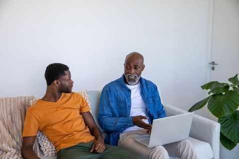 Father-Son Conversation with Laptop in Modern Living Room