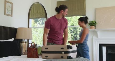 Couple Packing Suitcase in Bedroom Preparing for Travel Adventure
