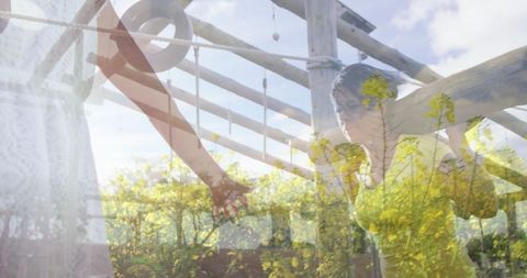 Woman relaxing under pergola in field of yellow flowers