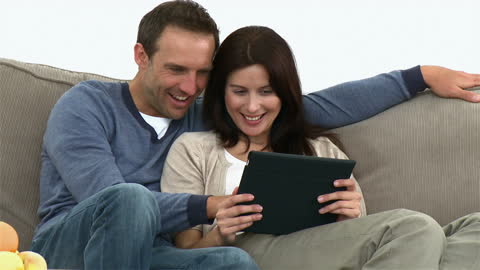 Happy Couple Relaxing at Home with Tablet