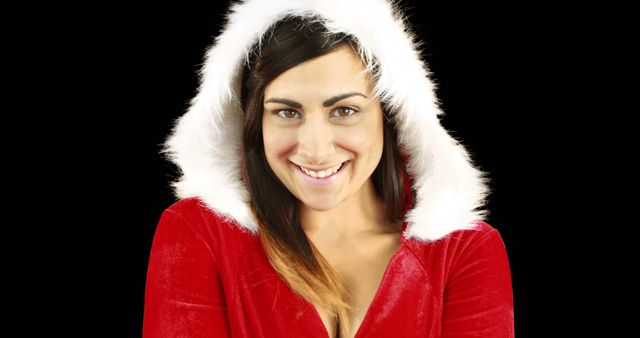 This engaging image shows a woman smiling while dressed in a Santa Claus costume with a fur-trimmed hood. Ideal for holiday-themed marketing materials, seasonal greetings, advertisements, social media posts emphasizing joy and celebration. Can also be used in articles or promotions surrounding Christmas and festive season activities.