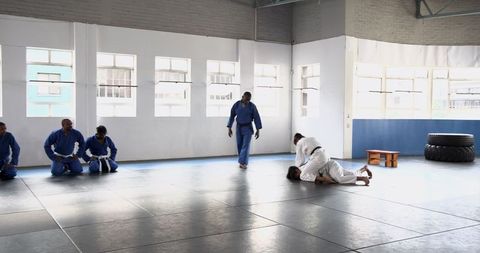 Diverse athletes training martial arts in professional gym space