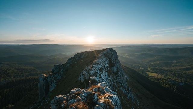 Sunrise lighting rocky ridge and jagged crest over expansive mountain wilderness