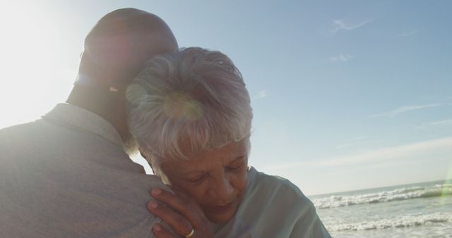 Biracial senior couple embracing at the beach. healthy outdoor leisure time by the sea.