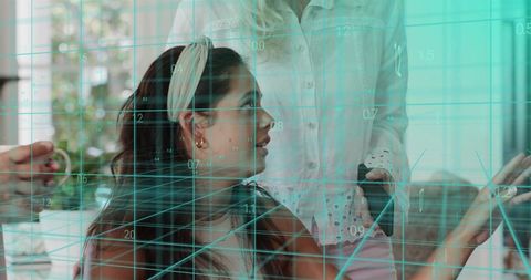 Four women collaborating with augmented reality grid in modern living room