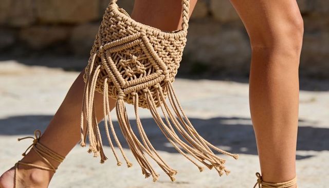Boho macrame fringe bag swinging while walking in ankle-wrap sandals on sunlit stone