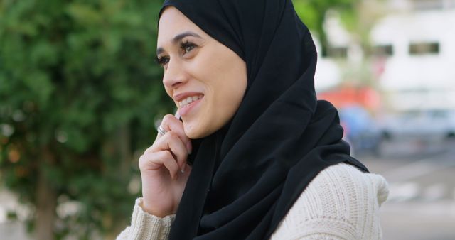 Smiling Muslim Woman in Outdoor Setting Wearing Hijab and Sweater - Download Free Stock Images Pikwizard.com