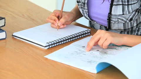 Student Studying with Books and Notes in Classroom