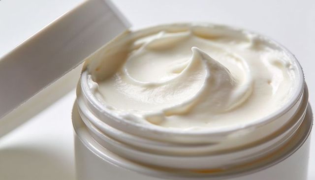 Close-up jar of moisturizer with whipped ivory cream texture for luxury skincare packaging