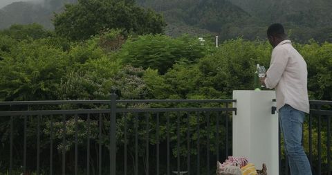 Man arranging outdoor patio seating amid lush nature
